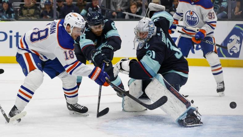 Nov 11, 2023; Seattle, Washington, USA; Edmonton Oilers left wing Zach Hyman (18) scores his second goal of the during the first period against Seattle Kraken goaltender Philipp Grubauer (31) and defenseman Adam Larsson (6)  at Climate Pledge Arena. Mandatory Credit: Joe Nicholson-USA TODAY Sports