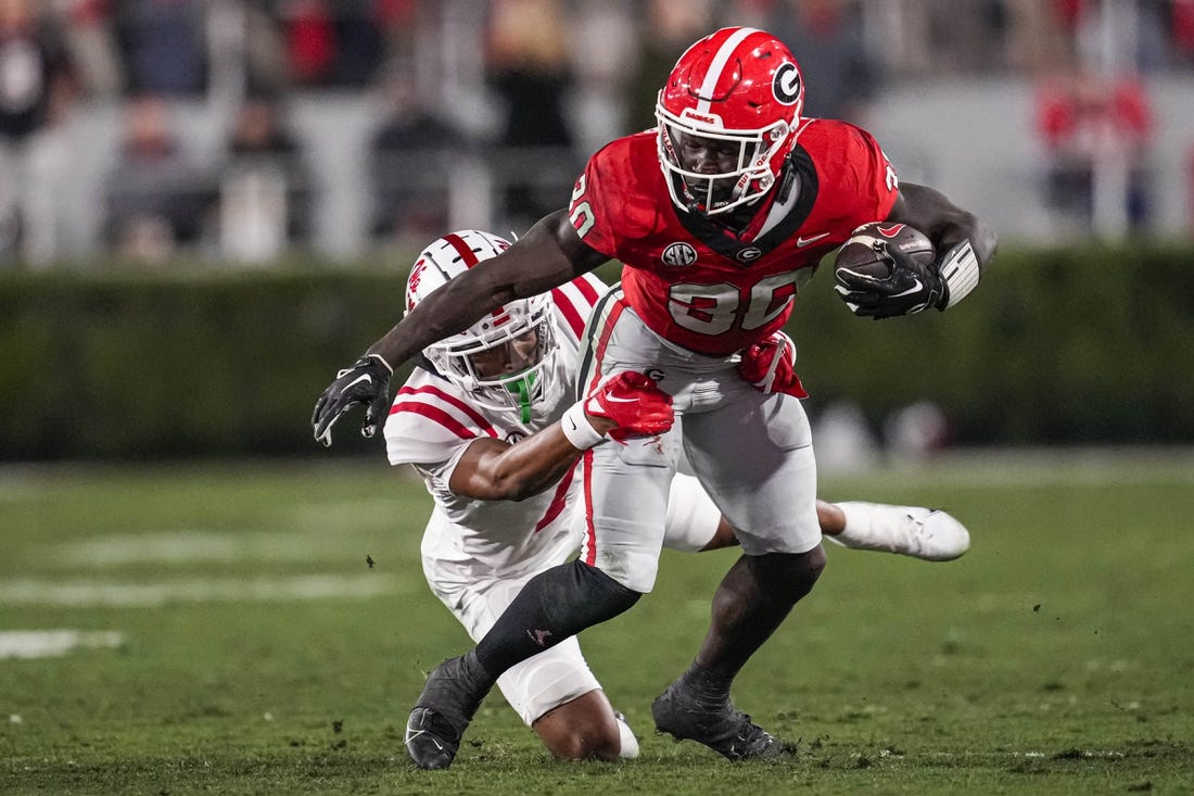 Nov 11, 2023; Athens, Georgia, USA; Georgia Bulldogs running back Daijun Edwards (30) runs against Mississippi Rebels cornerback Deantre Prince (7) during the first half at Sanford Stadium. Mandatory Credit: Dale Zanine-USA TODAY Sports