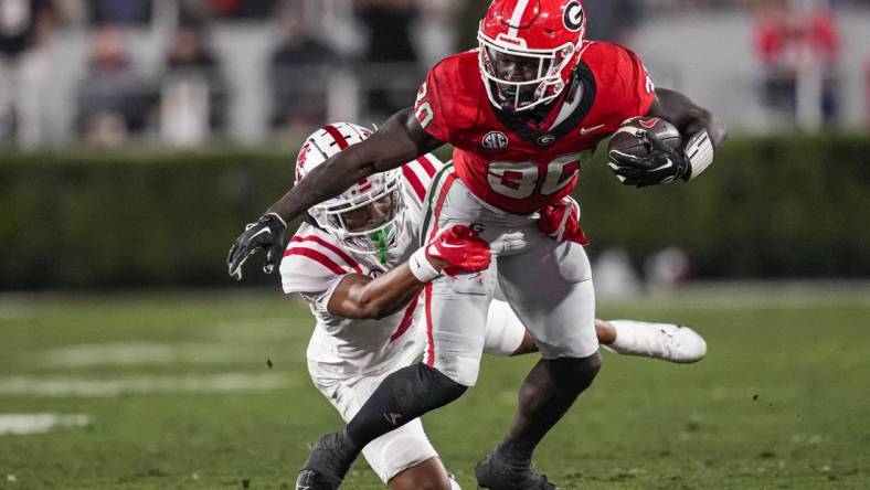 Nov 11, 2023; Athens, Georgia, USA; Georgia Bulldogs running back Daijun Edwards (30) runs against Mississippi Rebels cornerback Deantre Prince (7) during the first half at Sanford Stadium. Mandatory Credit: Dale Zanine-USA TODAY Sports