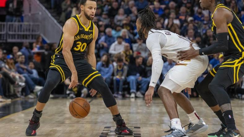 Nov 11, 2023; San Francisco, California, USA;  Golden State Warriors guard Stephen Curry (30) dribbles the basketball against Cleveland Cavaliers guard Darius Garland (10) during the fourth quarter at Chase Center. Mandatory Credit: Neville E. Guard-USA TODAY Sports