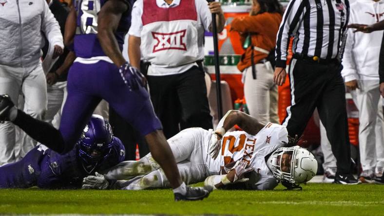 Nov 11, 2023; Fort Worth, Texas, USA; Texas Longhorns running back Jonathon Brooks (24) is brought down by TCU Horned Frogs cornerback Josh Newton (3) during the game at Amon G. Carter Stadium. Mandatory Credit: Aaron E. Martinez-USA TODAY Sports