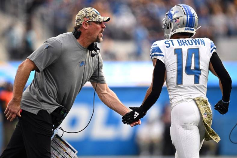 Nov 12, 2023; Inglewood, California, USA; Detroit Lions head coach Dan Campbell (left) congratulates wide receiver Amon-Ra St. Brown (14) after a Lions touchdown  against the Los Angeles Chargers during the first half at SoFi Stadium. Mandatory Credit: Orlando Ramirez-USA TODAY Sports