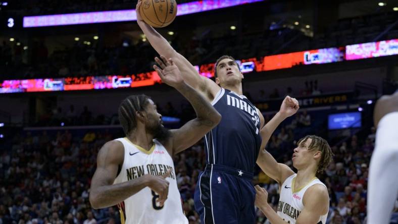 Nov 12, 2023; New Orleans, Louisiana, USA; Dallas Mavericks center Dwight Powell (7) grabs a rebound between New Orleans Pelicans forward Naji Marshall (8) and guard Dyson Daniels (11) during the first half at the Smoothie King Center. Mandatory Credit: Matthew Hinton-USA TODAY Sports