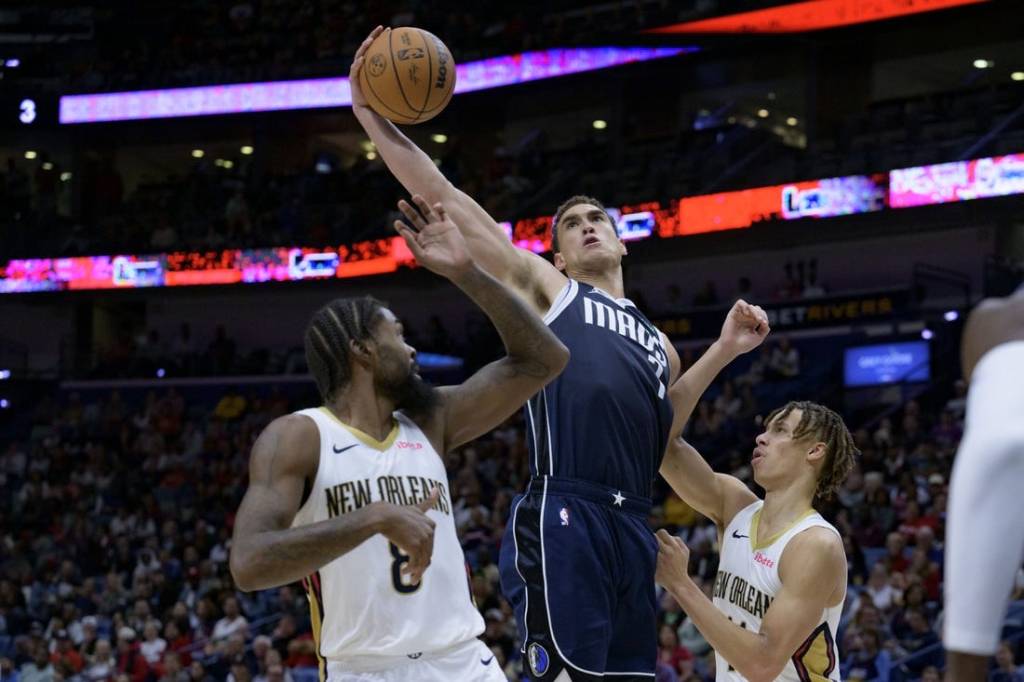 Nov 12, 2023; New Orleans, Louisiana, USA; Dallas Mavericks center Dwight Powell (7) grabs a rebound between New Orleans Pelicans forward Naji Marshall (8) and guard Dyson Daniels (11) during the first half at the Smoothie King Center. Mandatory Credit: Matthew Hinton-USA TODAY Sports