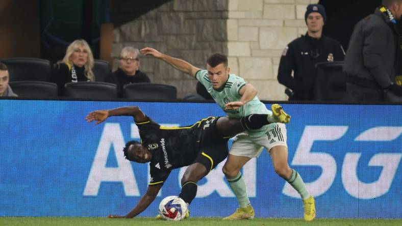 Nov 12, 2023; Columbus, Ohio, USA;  Columbus Crew midfielder Yaw Yeboah (14) is challenged by Atlanta United FC defender Brooks Lennon (11) during the second half at Lower.com Field. Mandatory Credit: Trevor Ruszkowski-USA TODAY Sports