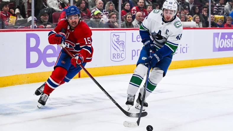 Nov 12, 2023; Montreal, Quebec, CAN; Vancouver Canucks defenseman Quinn Hughes (43) defends the puck against Montreal Canadiens center Alex Newhook (15) during the second period at Bell Centre. Mandatory Credit: David Kirouac-USA TODAY Sports