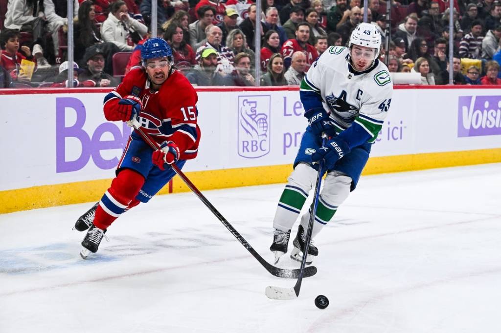 Nov 12, 2023; Montreal, Quebec, CAN; Vancouver Canucks defenseman Quinn Hughes (43) defends the puck against Montreal Canadiens center Alex Newhook (15) during the second period at Bell Centre. Mandatory Credit: David Kirouac-USA TODAY Sports