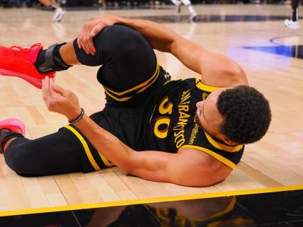 Nov 12, 2023; San Francisco, California, USA; Golden State Warriors guard Stephen Curry (30) holds his leg as he goes down on the floor during the fourth quarter against the Minnesota Timberwolves at Chase Center. Mandatory Credit: Kelley L Cox-USA TODAY Sports