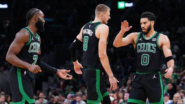 Nov 13, 2023; Boston, Massachusetts, USA; Boston Celtics forward Jayson Tatum (0), center Kristaps Porzingis (8) and guard Jaylen Brown (7) react after a play against th eNew York Knicks in the second quarter at TD Garden. Mandatory Credit: David Butler II-USA TODAY Sports