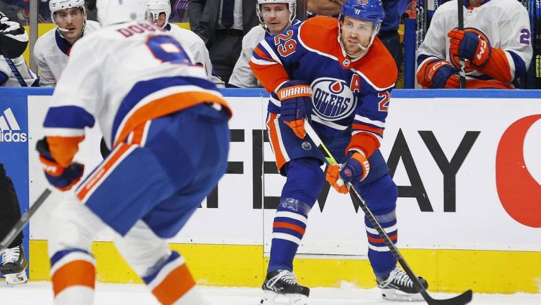 Nov 13, 2023; Edmonton, Alberta, CAN; Edmonton Oilers forward Leon Draisaitl (29) looks to make a pass in front of New York Islanders defensemen Noah Dobson (8) during the first period at Rogers Place. Mandatory Credit: Perry Nelson-USA TODAY Sports