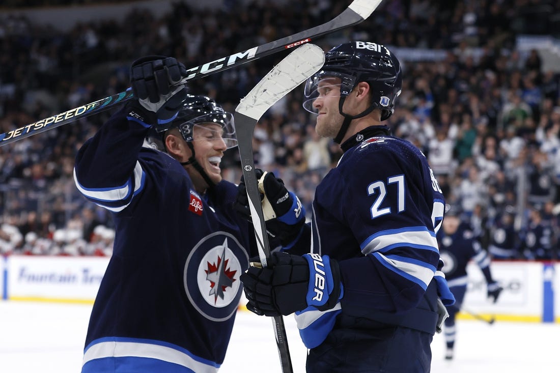 Nov 14, 2023; Winnipeg, Manitoba, CAN; Winnipeg Jets left wing Nikolaj Ehlers (27) celebrates his second period goal with Winnipeg Jets defenseman Nate Schmidt (88) against the New Jersey Devils at Canada Life Centre. Mandatory Credit: James Carey Lauder-USA TODAY Sports