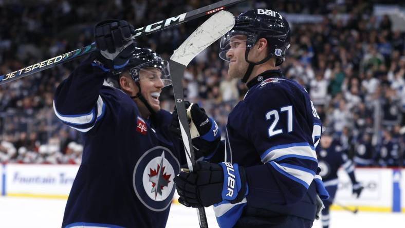 Nov 14, 2023; Winnipeg, Manitoba, CAN; Winnipeg Jets left wing Nikolaj Ehlers (27) celebrates his second period goal with Winnipeg Jets defenseman Nate Schmidt (88) against the New Jersey Devils at Canada Life Centre. Mandatory Credit: James Carey Lauder-USA TODAY Sports