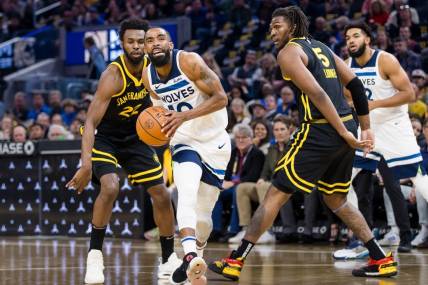 Nov 14, 2023; San Francisco, California, USA; Minnesota Timberwolves guard Mike Conley (10) prepares to shoot in front of Golden State Warriors forward Kevon Looney (5) and forward Andrew Wiggins (22) during the first half at Chase Center. Mandatory Credit: John Hefti-USA TODAY Sports