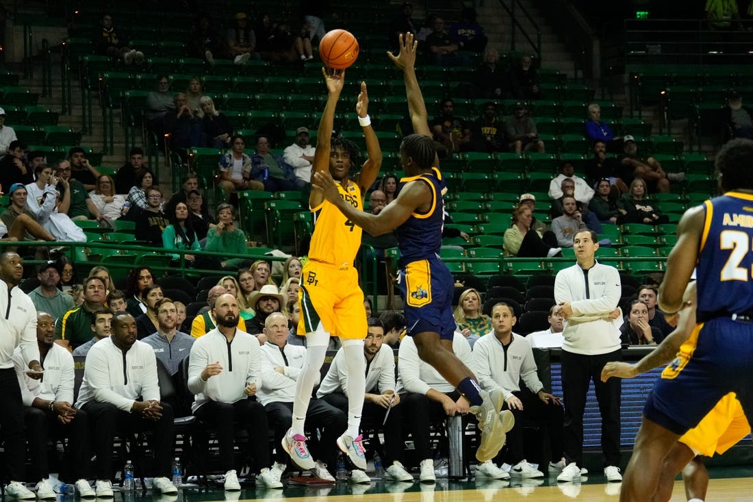 Nov 14, 2023; Waco, Texas, USA; Baylor Bears guard Ja'Kobe Walter (4) makes a three point shot against UMKC Kangaroos guard Jayson Petty (1) during the second half at Ferrell Center. Mandatory Credit: Chris Jones-USA TODAY Sports