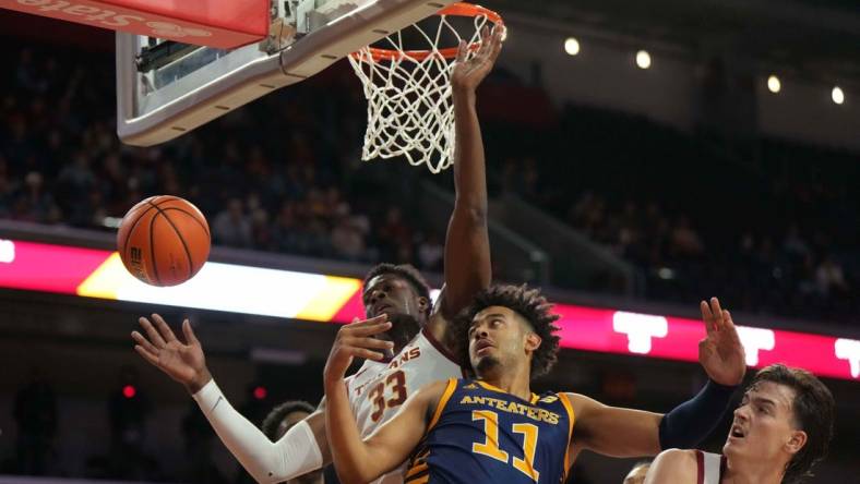 Nov 14, 2023; Los Angeles, California, USA; UC Irvine Anteaters forward Devin Tillis (11) battles for the ball with Southern California Trojans forward Kijani Wright (33) and forward Harrison Hornery (30) in the first half at Galen Center. Mandatory Credit: Kirby Lee-USA TODAY Sports