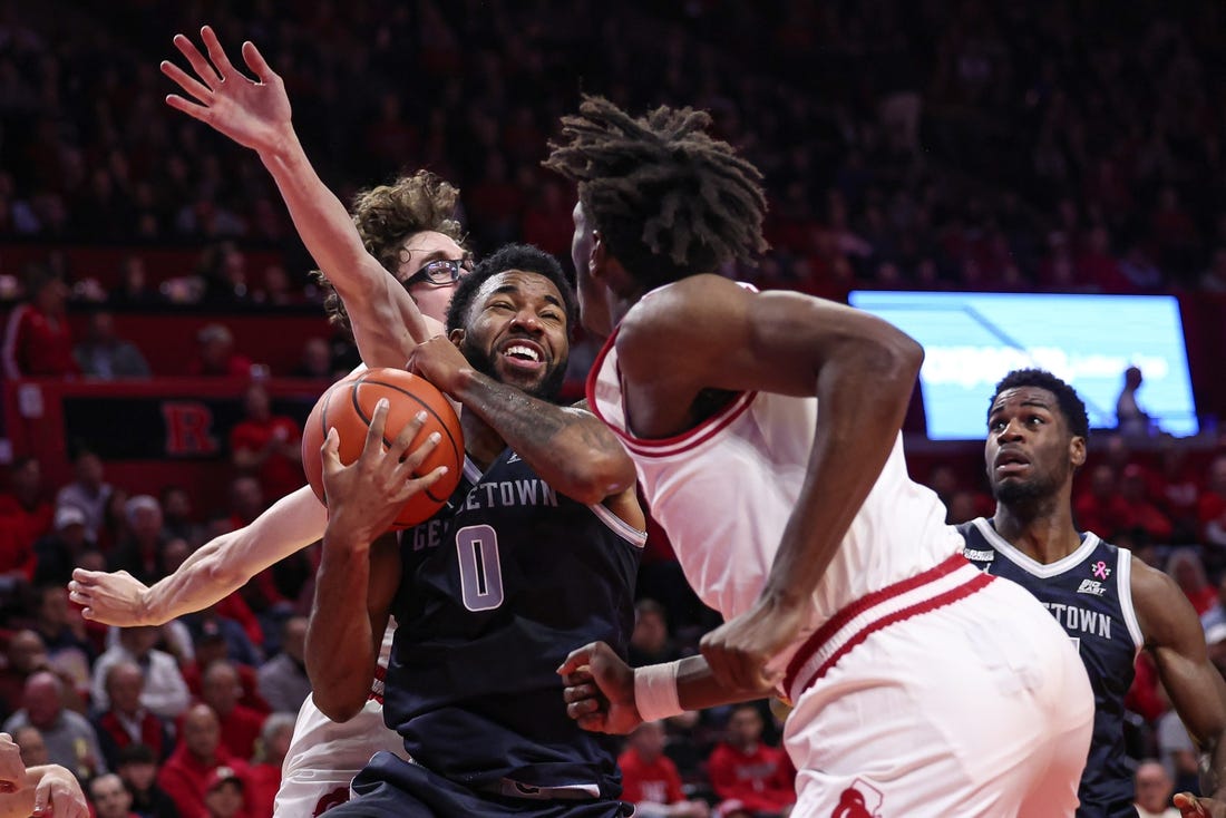 Nov 15, 2023; Piscataway, New Jersey, USA; Georgetown Hoyas guard Dontrez Styles (0) drives to the basket against Rutgers Scarlet Knights guard Gavin Griffiths (10) and forward Antwone Woolfolk (13) during the first half at Jersey Mike's Arena. Mandatory Credit: Vincent Carchietta-USA TODAY Sports