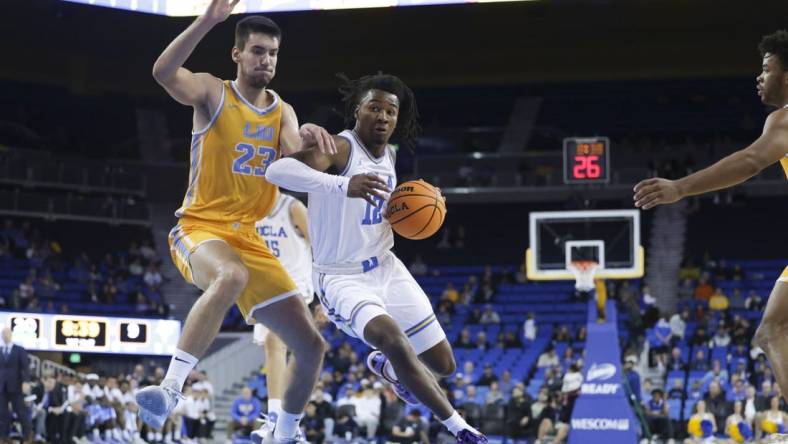 Nov 15, 2023; Los Angeles, California, USA; UCLA guard Sebastian Mack (12) drives the ball against Long Island University forward Nikola Djapa (23) during the first half at Pauley Pavilion presented by Wescom. Mandatory Credit: Yannick Peterhans-USA TODAY Sports