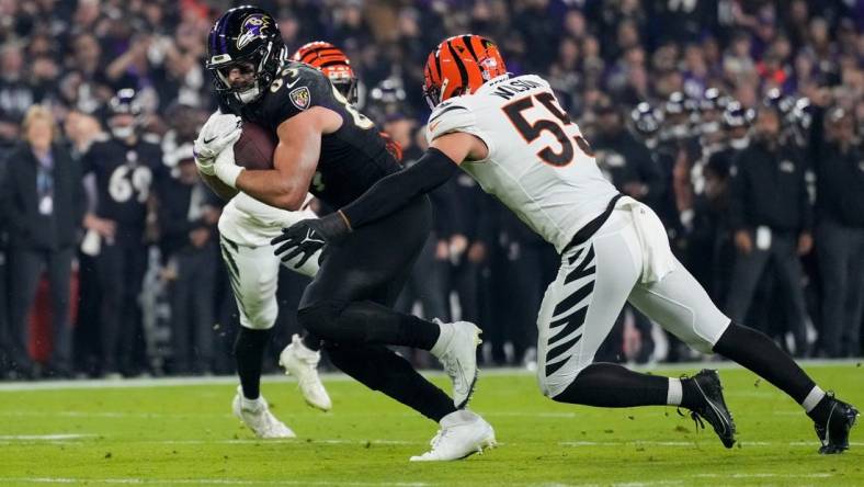 Baltimore Ravens tight end Mark Andrews (89) fights a tackle from Cincinnati Bengals linebacker Logan Wilson (55) in the first quarter of the NFL Week 11 game between the Baltimore Ravens and the Cincinnati Bengals at M&T Bank Stadium in Baltimore on Thursday, Nov. 16, 2023.