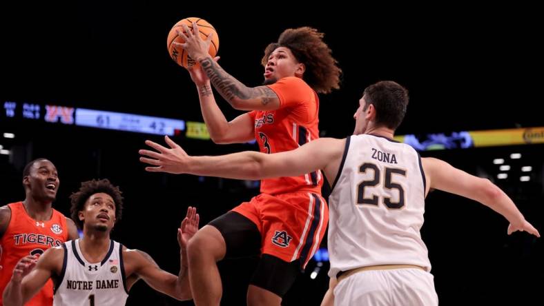 Nov 16, 2023; Brooklyn, New York, USA; Auburn Tigers guard Tre Donaldson (3) drives to the basket against Notre Dame Fighting Irish guard Julian Roper II (1) and forward Matt Zona (25) during the second half at Barclays Center. Mandatory Credit: Brad Penner-USA TODAY Sports