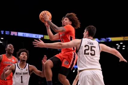 Nov 16, 2023; Brooklyn, New York, USA; Auburn Tigers guard Tre Donaldson (3) drives to the basket against Notre Dame Fighting Irish guard Julian Roper II (1) and forward Matt Zona (25) during the second half at Barclays Center. Mandatory Credit: Brad Penner-USA TODAY Sports