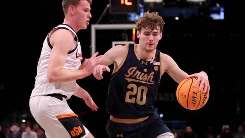 Nov 17, 2023; Brookyln, NY, USA; Notre Dame Fighting Irish guard J.R. Konieczny (20) controls the ball against Oklahoma State Cowboys guard Connor Dow (13) during the first half at Barclays Center. Mandatory Credit: Brad Penner-USA TODAY Sports