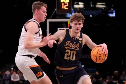 Nov 17, 2023; Brookyln, NY, USA; Notre Dame Fighting Irish guard J.R. Konieczny (20) controls the ball against Oklahoma State Cowboys guard Connor Dow (13) during the first half at Barclays Center. Mandatory Credit: Brad Penner-USA TODAY Sports