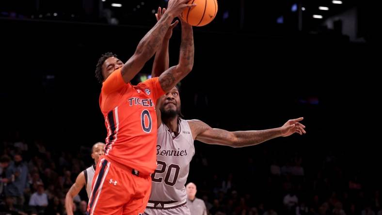 Nov 17, 2023; Brookyln, NY, USA; Auburn Tigers guard K.D. Johnson (0) grabs a rebound against St. Bonaventure Bonnies center Noel Brown (20) during the first half at Barclays Center. Mandatory Credit: Brad Penner-USA TODAY Sports