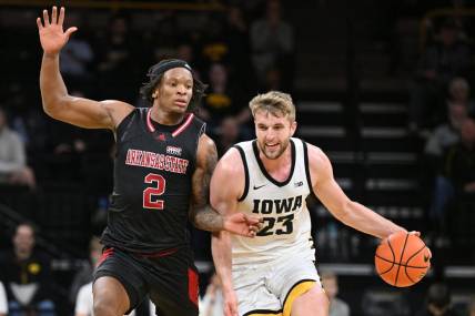 Nov 17, 2023; Iowa City, Iowa, USA; Iowa Hawkeyes forward Ben Krikke (23) controls the ball as Arkansas State Red Wolves guard Freddy Hicks (2) defends during the first half at Carver-Hawkeye Arena. Mandatory Credit: Jeffrey Becker-USA TODAY Sports