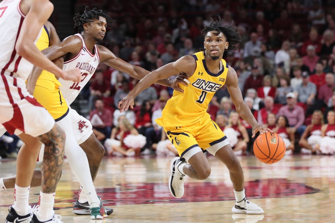 Nov 17, 2023; Fayetteville, Arkansas, USA; UNC Greensboro Spartans guard Keyshaun Langley (0) dribbles around Arkansas Razorbacks guard Truman Mark (12) during the first half at Bud Walton Arena. Mandatory Credit: Nelson Chenault-USA TODAY Sports