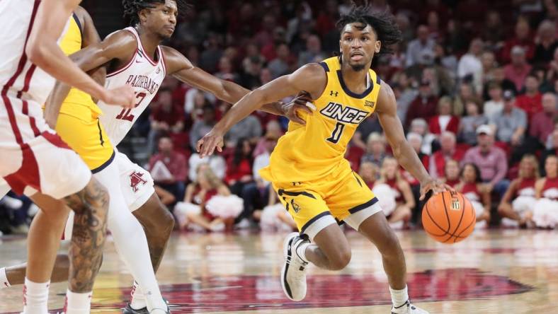 Nov 17, 2023; Fayetteville, Arkansas, USA; UNC Greensboro Spartans guard Keyshaun Langley (0) dribbles around Arkansas Razorbacks guard Truman Mark (12) during the first half at Bud Walton Arena. Mandatory Credit: Nelson Chenault-USA TODAY Sports