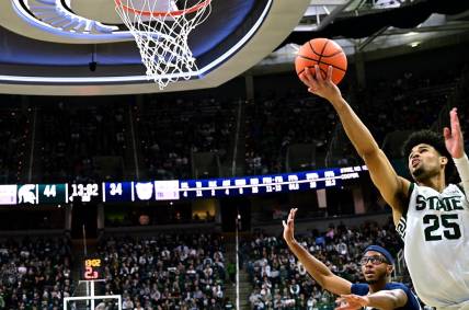 Nov 17, 2023; East Lansing, Michigan, USA; Michigan State Spartans forward Malik Hall (25) puts a shot off the glass past Butler Bulldogs center Andre Screen (23) during the second half at Jack Breslin Student Events Center. Mandatory Credit: Dale Young-USA TODAY Sports