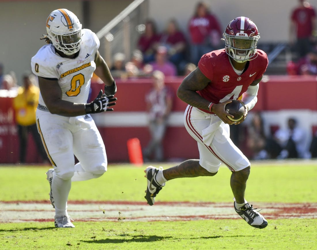 Nov 18, 2023; Tuscaloosa, Alabama, USA;  Alabama Crimson Tide quarterback Jalen Milroe (4) rolls out with Chattanooga Mocs defensive lineman Quay Wiggles (0) giving chase at Bryant-Denny Stadium. Mandatory Credit: Gary Cosby Jr.-USA TODAY Sports