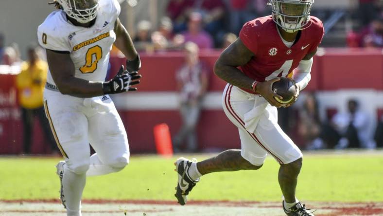 Nov 18, 2023; Tuscaloosa, Alabama, USA;  Alabama Crimson Tide quarterback Jalen Milroe (4) rolls out with Chattanooga Mocs defensive lineman Quay Wiggles (0) giving chase at Bryant-Denny Stadium. Mandatory Credit: Gary Cosby Jr.-USA TODAY Sports