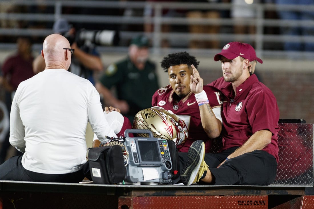 Nov 18, 2023; Tallahassee, Florida, USA; Florida State Seminoles quarterback Jordan Travis (13) waves to fans while being carted off after an injury against the North Alabama Lions during the first quarter at Doak S. Campbell Stadium. Mandatory Credit: Morgan Tencza-USA TODAY Sports