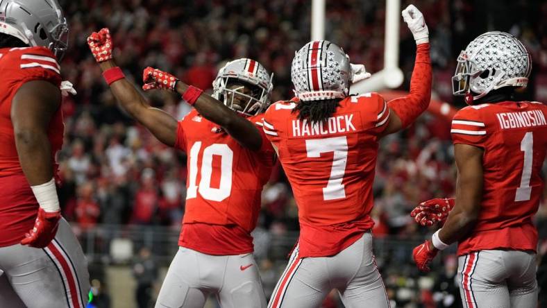 Nov 18, 2023; Columbus, Ohio, USA; Ohio State Buckeyes cornerback Jordan Hancock (7) and cornerback Denzel Burke (10) celebrate an interception by Hancock during the second half of the NCAA football game against the Minnesota Golden Gophers at Ohio Stadium. Ohio State won 37-3.