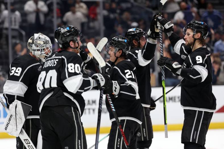 Nov 18, 2023; Los Angeles, California, USA; Los Angeles Kings center Adrian Kempe (9) high-fives with center Anze Kopitar (11) as goaltender Cam Talbot (39) and left wing Pierre-Luc Dubois (80) and defenseman Jordan Spence (21) celebrate a win after defeating the St. Louis Blues 5-1 at Crypto.com Arena. Mandatory Credit: Kiyoshi Mio-USA TODAY Sports