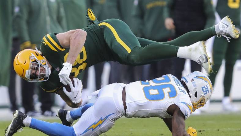 Sunday, November 19, 2023; Green Bay, WI; Green Bay Packers tight end Luke Musgrave (88) is upended by Los Angeles Chargers cornerback Asante Samuel Jr. (26) during the game at Lambeau Field. Mandatory Credit: Tork Mason-USA TODAY NETWORK