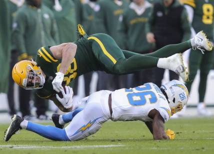 Sunday, November 19, 2023; Green Bay, WI; Green Bay Packers tight end Luke Musgrave (88) is upended by Los Angeles Chargers cornerback Asante Samuel Jr. (26) during the game at Lambeau Field. Mandatory Credit: Tork Mason-USA TODAY NETWORK