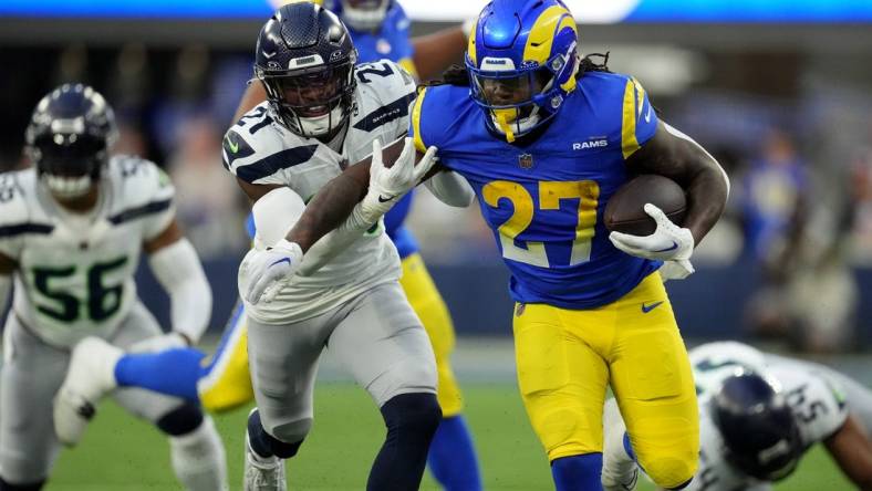 Nov 19, 2023; Inglewood, California, USA; Los Angeles Rams running back Darrell Henderson Jr. (27) runs against Seattle Seahawks cornerback Devon Witherspoon (21) in the second half at SoFi Stadium. Mandatory Credit: Kirby Lee-USA TODAY Sports