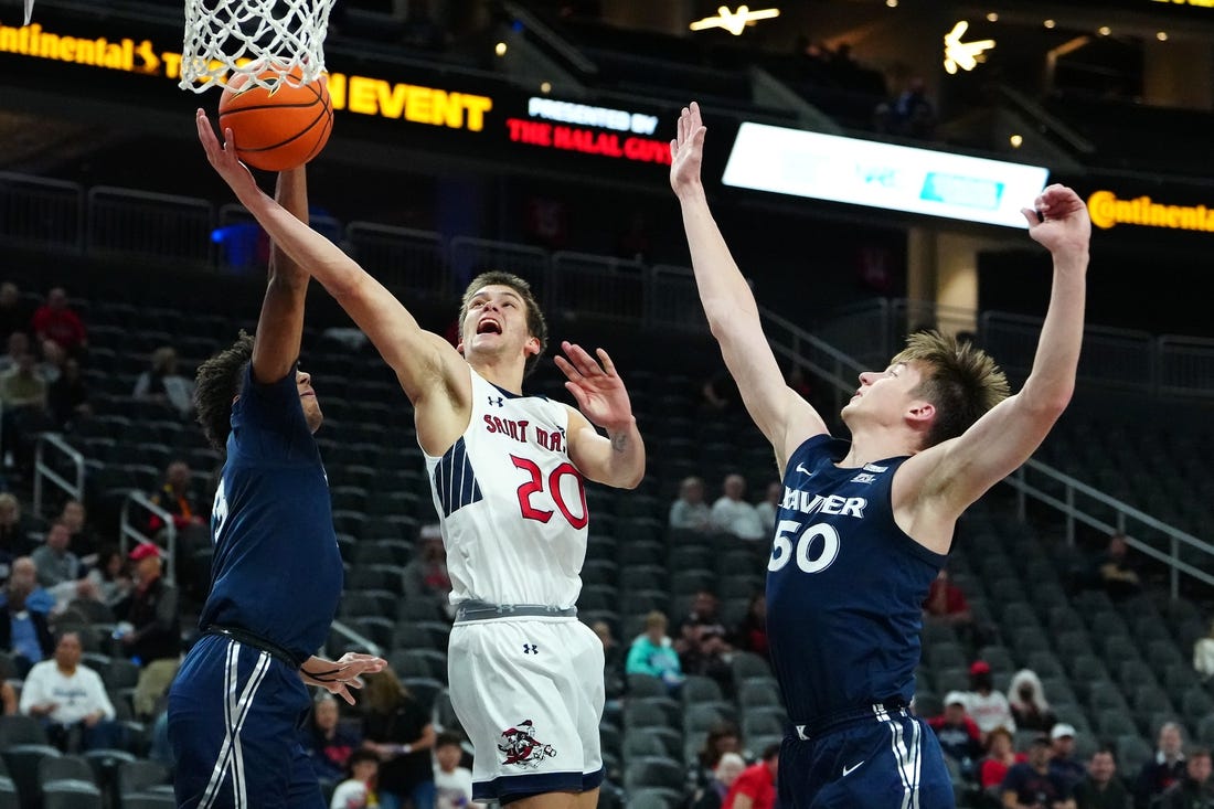 Nov 19, 2023; Las Vegas, NV, USA; St. Mary's Gaels guard Aidan Mahaney (20) shoots between Xavier Musketeers guard Dailyn Swain (3) and forward Gytis Nemeiksa (50) during the first half at T-Mobile Arena. Mandatory Credit: Stephen R. Sylvanie-USA TODAY Sports