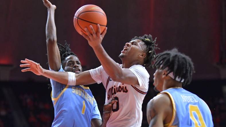 Nov 19, 2023; Champaign, Illinois, USA;  Illinois Fighting Illini guard Terrence Shannon Jr. (0) drives to the basket as Southern Jaguars forward JaRonn Wilkens (1) defends during the first half at State Farm Center. Mandatory Credit: Ron Johnson-USA TODAY Sports