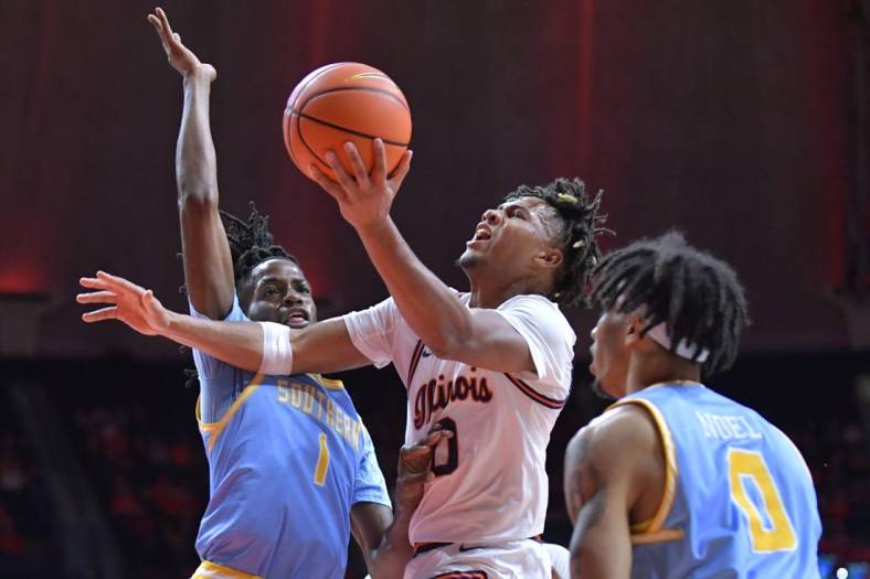 Nov 19, 2023; Champaign, Illinois, USA;  Illinois Fighting Illini guard Terrence Shannon Jr. (0) drives to the basket as Southern Jaguars forward JaRonn Wilkens (1) defends during the first half at State Farm Center. Mandatory Credit: Ron Johnson-USA TODAY Sports