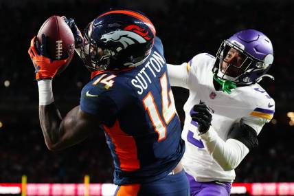 Nov 19, 2023; Denver, Colorado, USA; Denver Broncos wide receiver Courtland Sutton (14) catches a touchdown over Minnesota Vikings cornerback Mekhi Blackmon (5) in the fourth quarter at Empower Field at Mile High. Mandatory Credit: Ron Chenoy-USA TODAY Sports