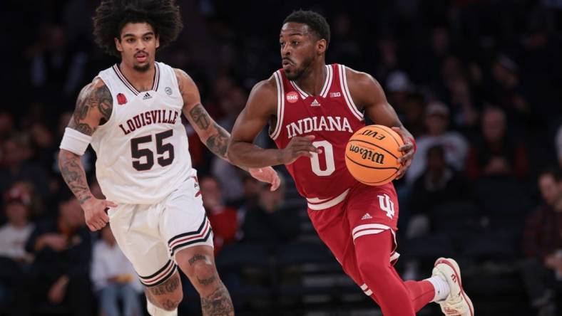 Nov 20, 2023; New York, NY, USA; Indiana Hoosiers guard Xavier Johnson (0) dribbles up court in front of Louisville Cardinals guard Skyy Clark (55) during the second half at Madison Square Garden. Mandatory Credit: Vincent Carchietta-USA TODAY Sports