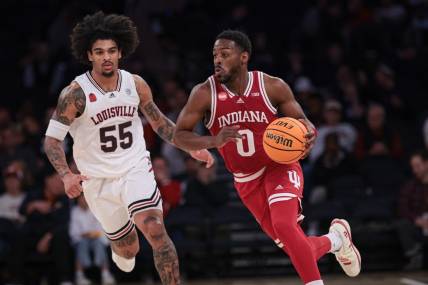 Nov 20, 2023; New York, NY, USA; Indiana Hoosiers guard Xavier Johnson (0) dribbles up court in front of Louisville Cardinals guard Skyy Clark (55) during the second half at Madison Square Garden. Mandatory Credit: Vincent Carchietta-USA TODAY Sports