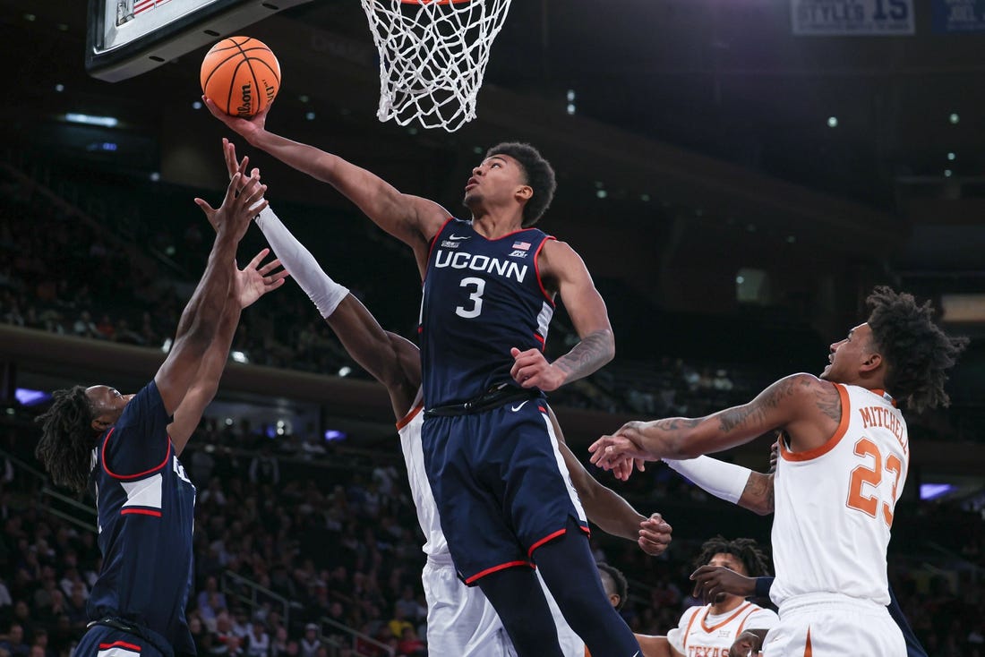 Nov 20, 2023; New York, NY, USA; Connecticut Huskies forward Jaylin Stewart (3) and guard Tristen Newton (2) rebound against Texas Longhorns forward Ze'Rik Onyema (21) and forward Dillon Mitchell (23) during the first half of the Empire Classic championship game at Madison Square Garden. Mandatory Credit: Vincent Carchietta-USA TODAY Sports