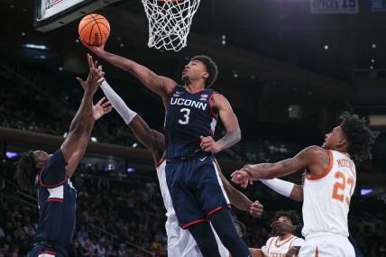 Nov 20, 2023; New York, NY, USA; Connecticut Huskies forward Jaylin Stewart (3) and guard Tristen Newton (2) rebound against Texas Longhorns forward Ze'Rik Onyema (21) and forward Dillon Mitchell (23) during the first half of the Empire Classic championship game at Madison Square Garden. Mandatory Credit: Vincent Carchietta-USA TODAY Sports