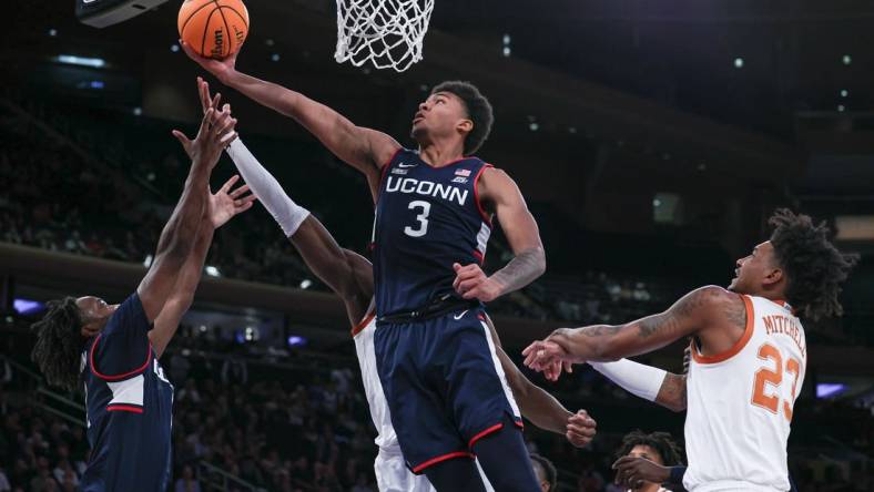 Nov 20, 2023; New York, NY, USA; Connecticut Huskies forward Jaylin Stewart (3) and guard Tristen Newton (2) rebound against Texas Longhorns forward Ze'Rik Onyema (21) and forward Dillon Mitchell (23) during the first half of the Empire Classic championship game at Madison Square Garden. Mandatory Credit: Vincent Carchietta-USA TODAY Sports