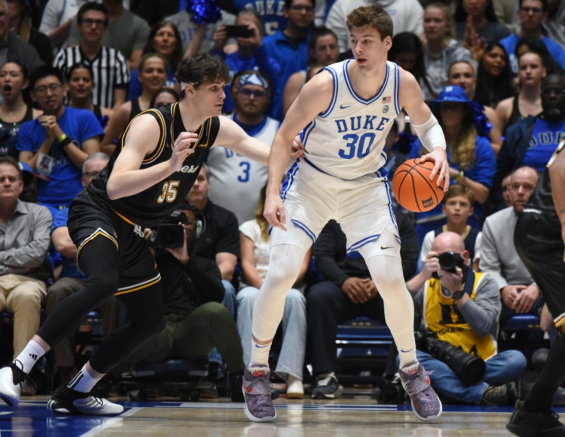 Nov 21, 2023; Durham, North Carolina, USA; Duke Blue Devils center Kyle Filipowski (30) controls the ball in front of La Salle Explorers forward Rokas Jucius (35) during the first half at Cameron Indoor Stadium. Mandatory Credit: Rob Kinnan-USA TODAY Sports