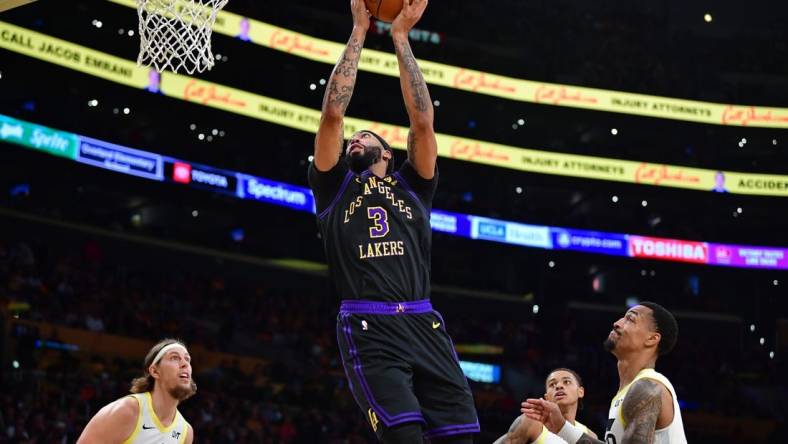 Nov 21, 2023; Los Angeles, California, USA; Los Angeles Lakers forward Anthony Davis (3) moves to the basket ahead of Utah Jazz forward John Collins (20) and forward Kelly Olynyk (41) during the first half at Crypto.com Arena. Mandatory Credit: Gary A. Vasquez-USA TODAY Sports